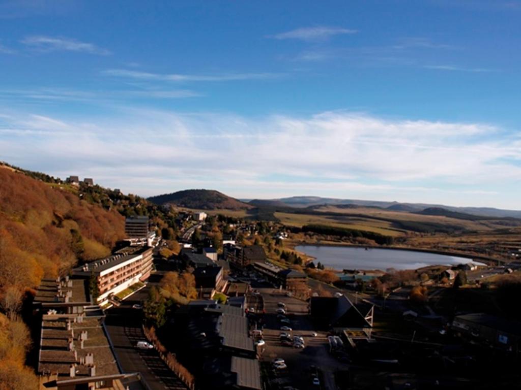 - une vue aride sur une ville avec un lac et des montagnes dans l'établissement Studio au pied des pistes à Super Besse - FR-1-814-110, à Besse-et-Saint-Anastaise