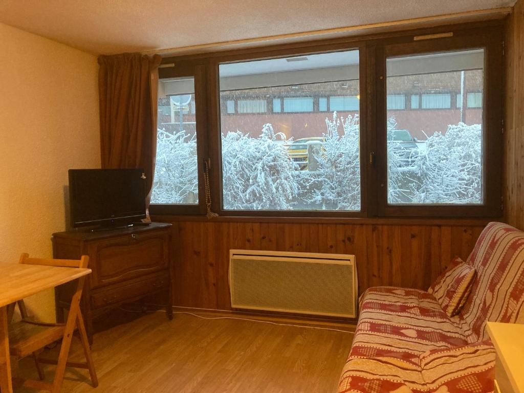 ein Wohnzimmer mit einer Couch und einem Fenster in der Unterkunft Studio cosy 4 pers au cœur de Super Besse - FR-1-814-118 in Besse-et-Saint-Anastaise