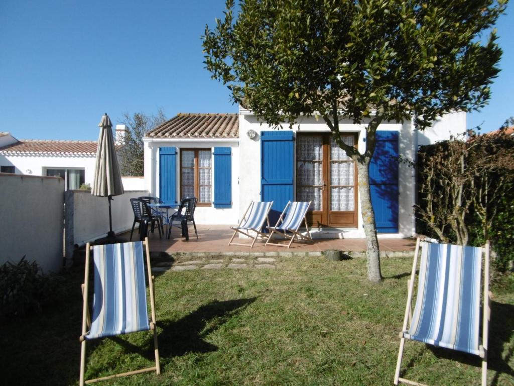 une terrasse avec 2 chaises longues et un parasol dans l'établissement Maison de campagne à L'Épine pour 4 personnes - FR-1-823-146, à LʼÉpine