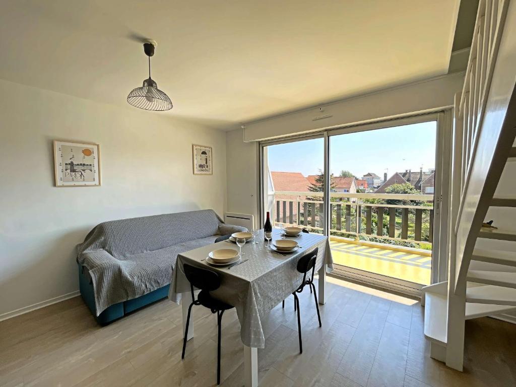 - une chambre avec une table, un lit et une grande fenêtre dans l'établissement Duplex rénové avec balcon et garage à Berck-Plage - FR-1-646-88, à Berck-sur-Mer