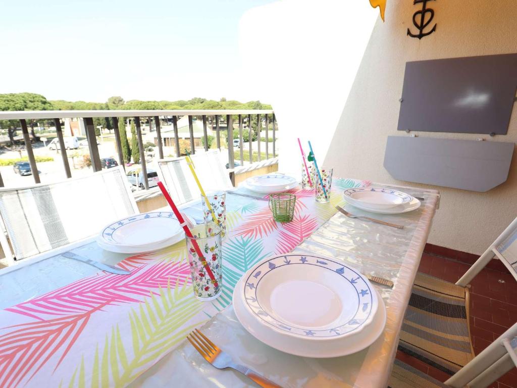 - une table avec des plaques sur le balcon dans l'établissement Studio ensoleillé à Port Camargue avec terrasse et parking - FR-1-307-283, au Grau-du-Roi