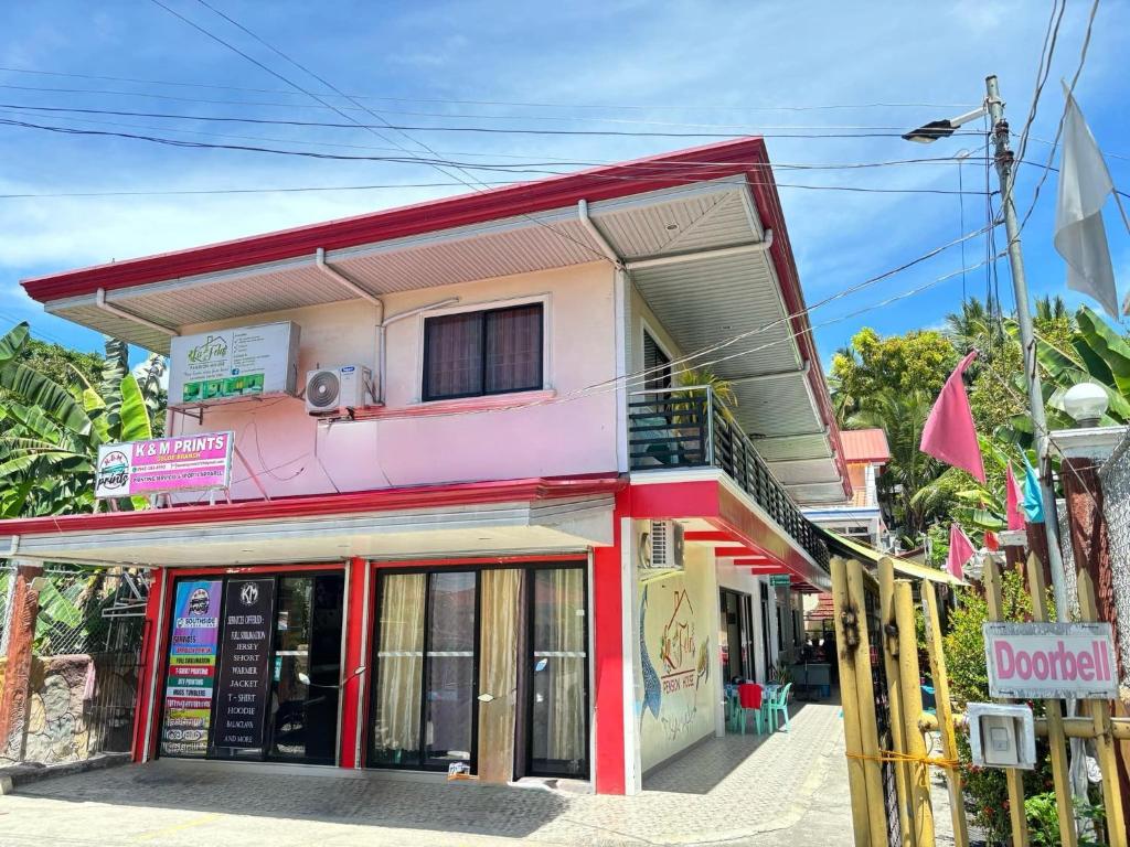 a pink building with a balcony on top of it at La Fela Pension House in Oslob