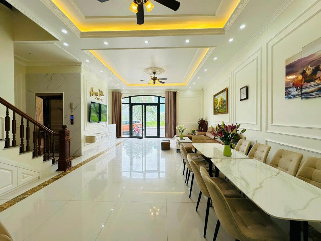 una gran sala de estar con una mesa larga y sillas en Chuỗi Villa 7 Phòng Ngủ Hạ Long - Harborbay HB77, en Ha Long