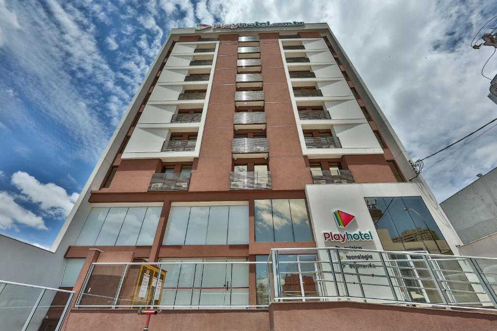 un edificio alto con un cartel en el costado en Play Hotel Águas Claras en Taguatinga