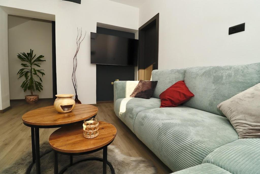 a living room with a couch and two tables at Fidelis Apartment - Walk to the Beach in Minutes in Novi Vinodolski