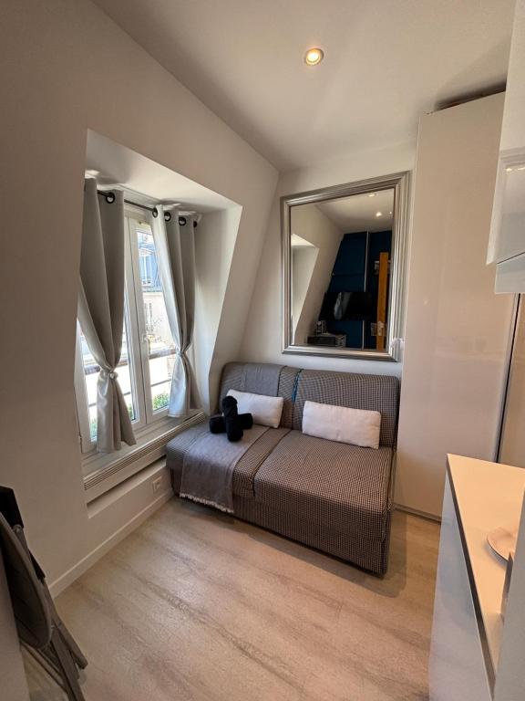 une chambre avec un lit et deux fenêtres dans l'établissement Paris 17 - Coeur Batignolles - Beau studio 10 m2 -110 sqf - Etat neuf - Calme - Idéal une personne - single occupancy, à Paris