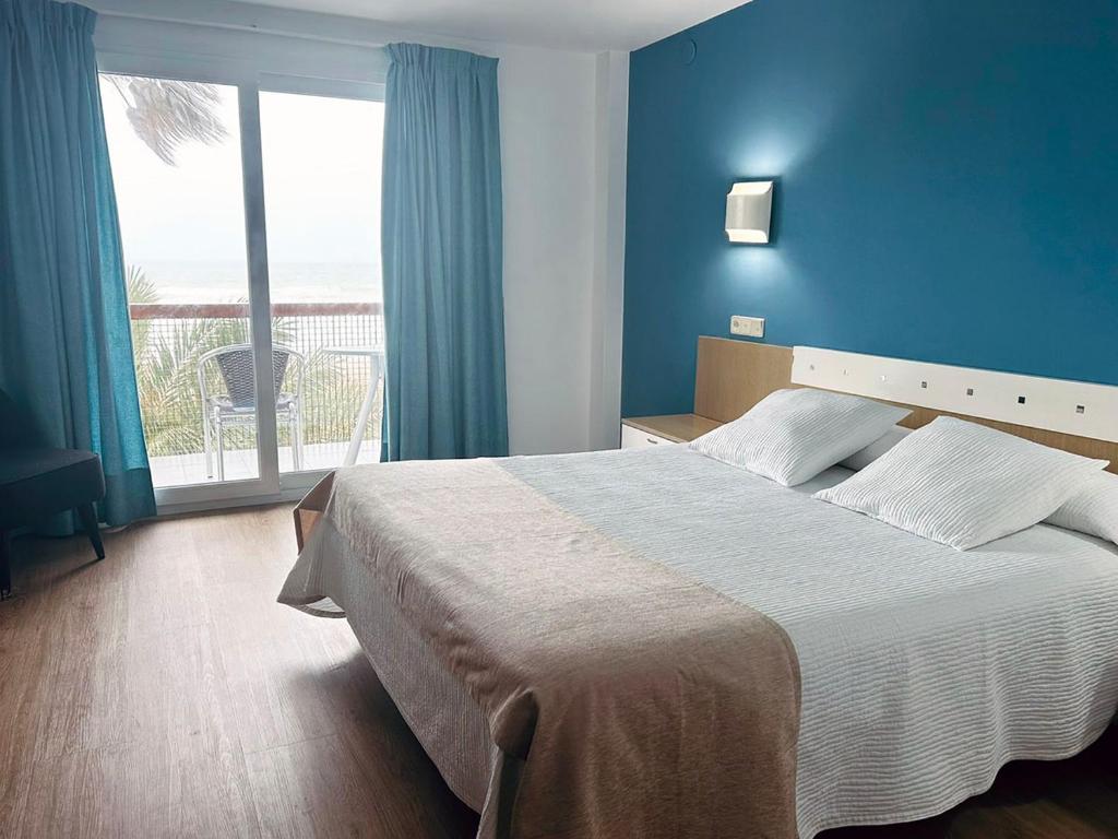 a bedroom with a large bed and a large window at La Cabaña in Peniscola