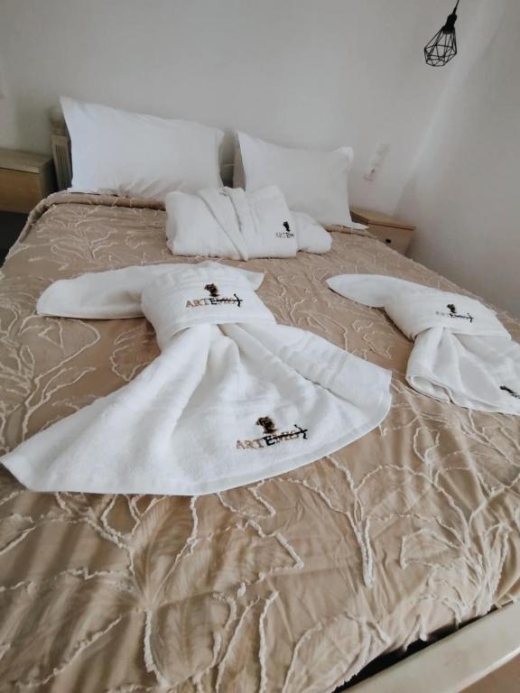 łóżko z białymi kocami i poduszkami w obiekcie ARTEMIS beach studios w mieście Kalamaki
