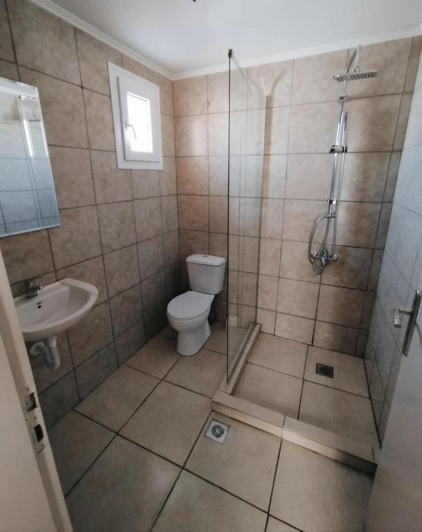 łazienka z prysznicem, toaletą i umywalką w obiekcie ARTEMIS beach studios w mieście Kalamaki