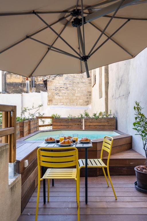 - une table et des chaises sous un parasol sur la terrasse dans l'établissement Le perchoir du Saint-Didier, à Avignon