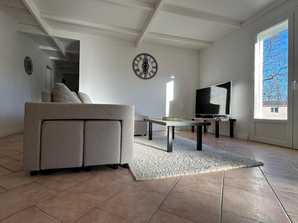 - un salon avec un canapé, une table et un réveil dans l'établissement Villa maison individuelle avec jardin arboré, aux Vans