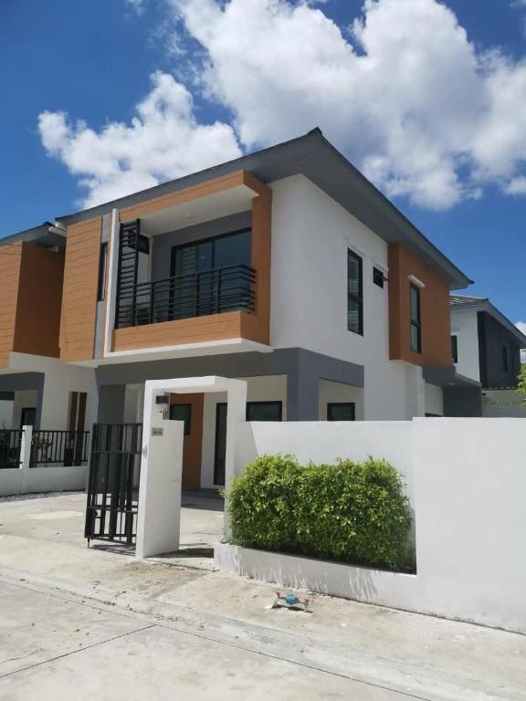 a house with a white fence in front of it at Nanzarie House in Bang Kew Yai
