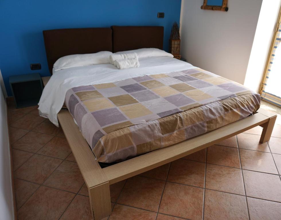 een bed met een houten frame in een slaapkamer bij La casetta rosa in Nicotera