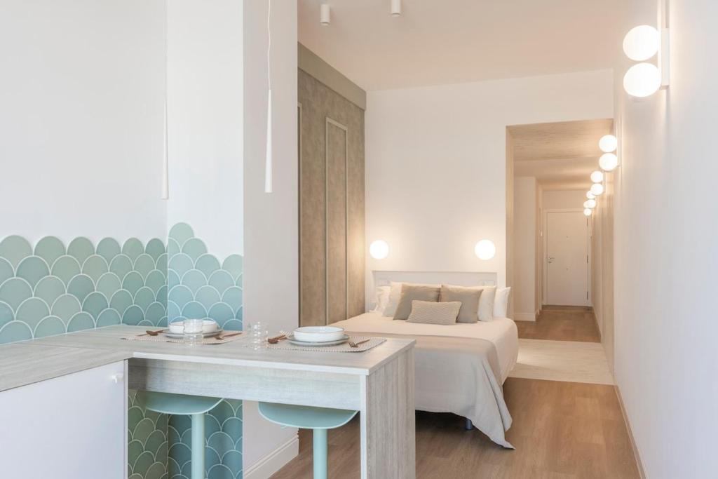 a bedroom with a bed and a table in a room at Exclusive beachfront apartment in Valencia