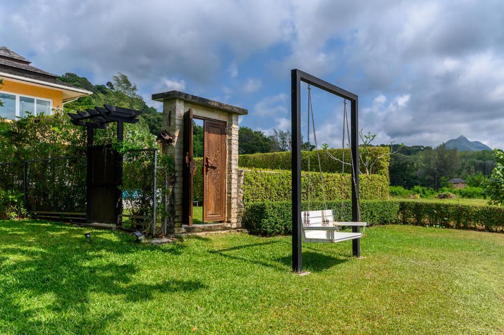 uno specchio e una panca in un cortile di Garden Cottage by Utalay Koh Chang a Ban Khlong Son