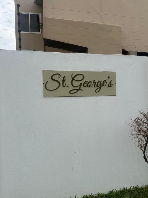 un cartello sul lato di un edificio bianco di St Georges Apartment a Accra