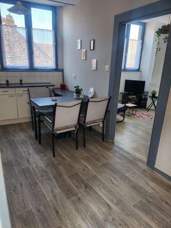 een eetkamer met een tafel en stoelen in een kamer bij Laelia place Rivotte in Besançon
