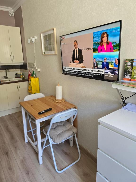 une pièce avec un bureau et une télévision sur un mur dans l'établissement Nid Douillet classé 2 étoiles depuis janvier 2023, à Le Mont-Dore