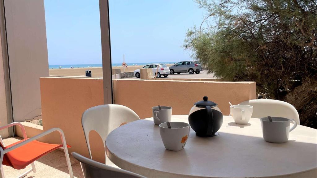 une table blanche avec un vase au-dessus dans l'établissement Appartement 2 pièces PORT LA NOUVELLE PN015-003, à Port-la-Nouvelle