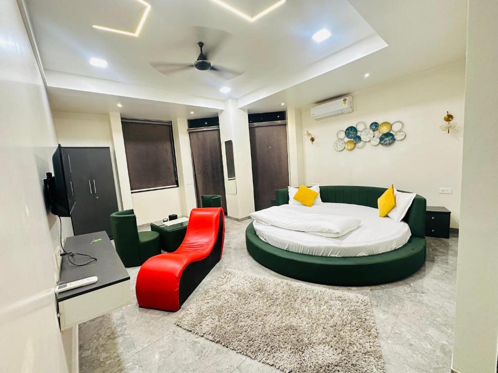 a bedroom with a bed and a red chair at Hotel Hill Top Inn -Near Baner Rd Pune in Pune