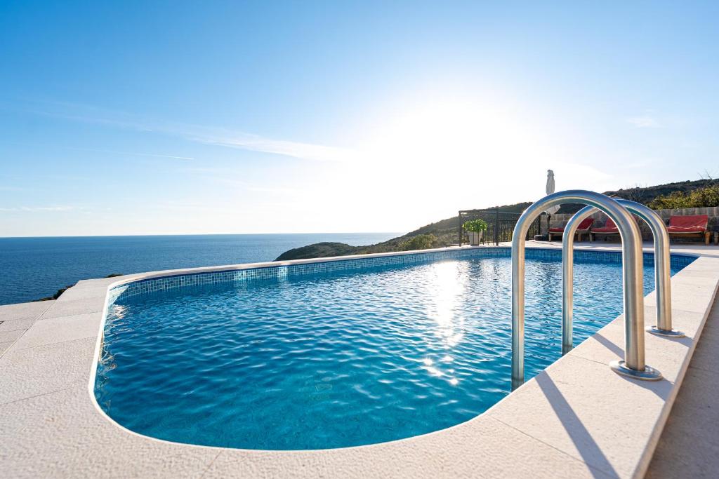 a swimming pool with a view of the ocean at Villa Maris in Lustica