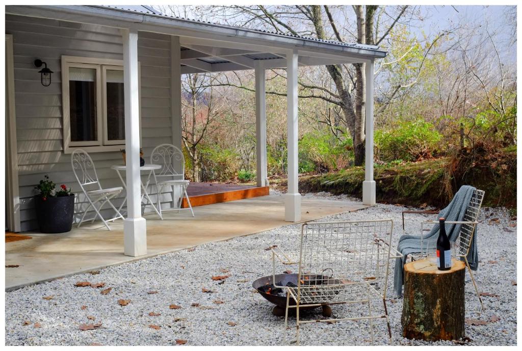 un porche grillagé d'une maison avec une table et des chaises dans l'établissement Garden View Cottage, à Stanley