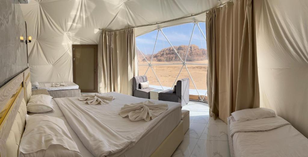a bedroom with a bed and a large window at Rum Star Desert Camp in Wadi Rum