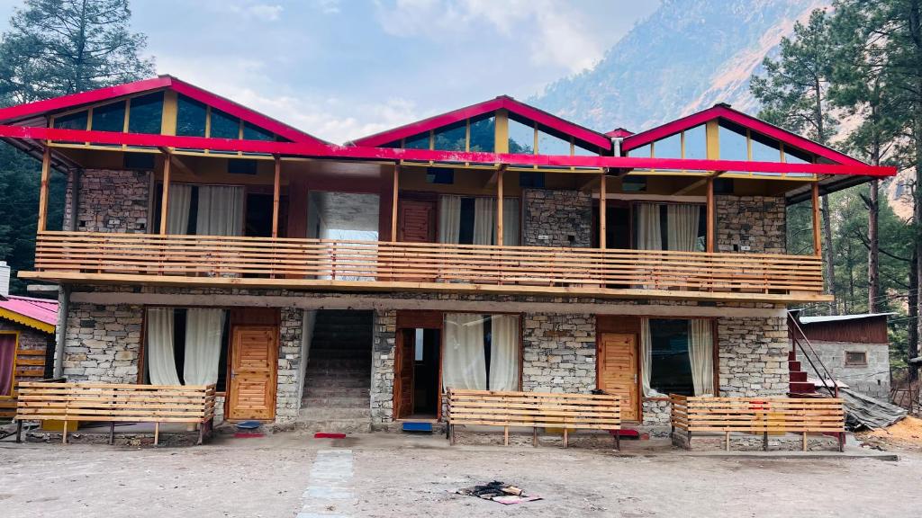 a large building with benches in front of it at Cherry 's Cottage in Kasol