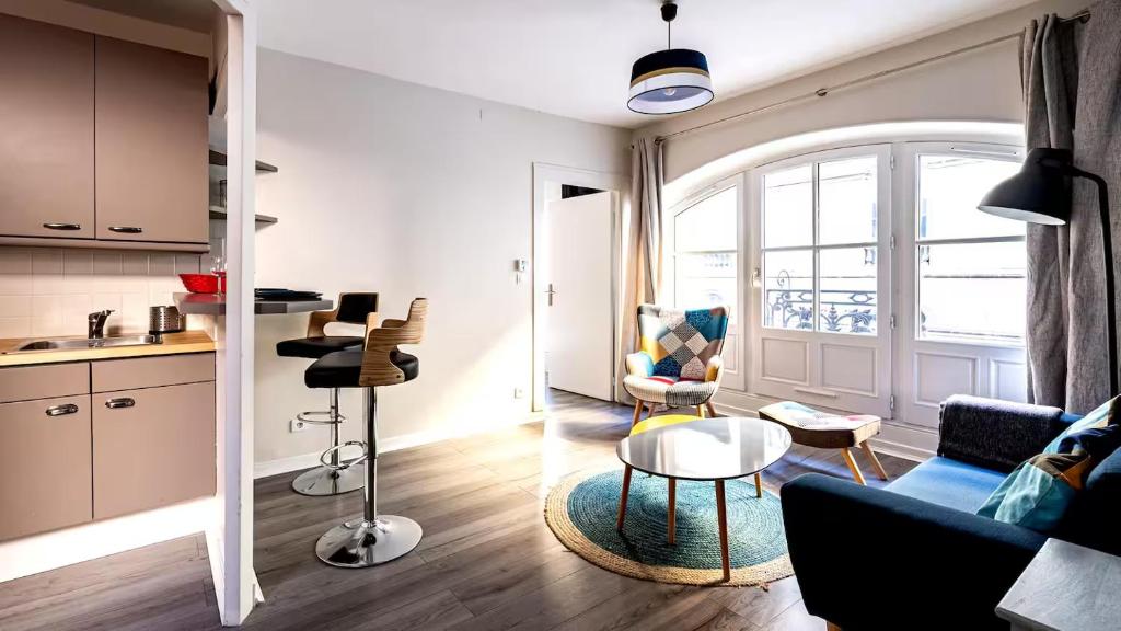 salon z kanapą i stołem w obiekcie L'Escapade Urbaine - Cosy et central w mieście Dijon