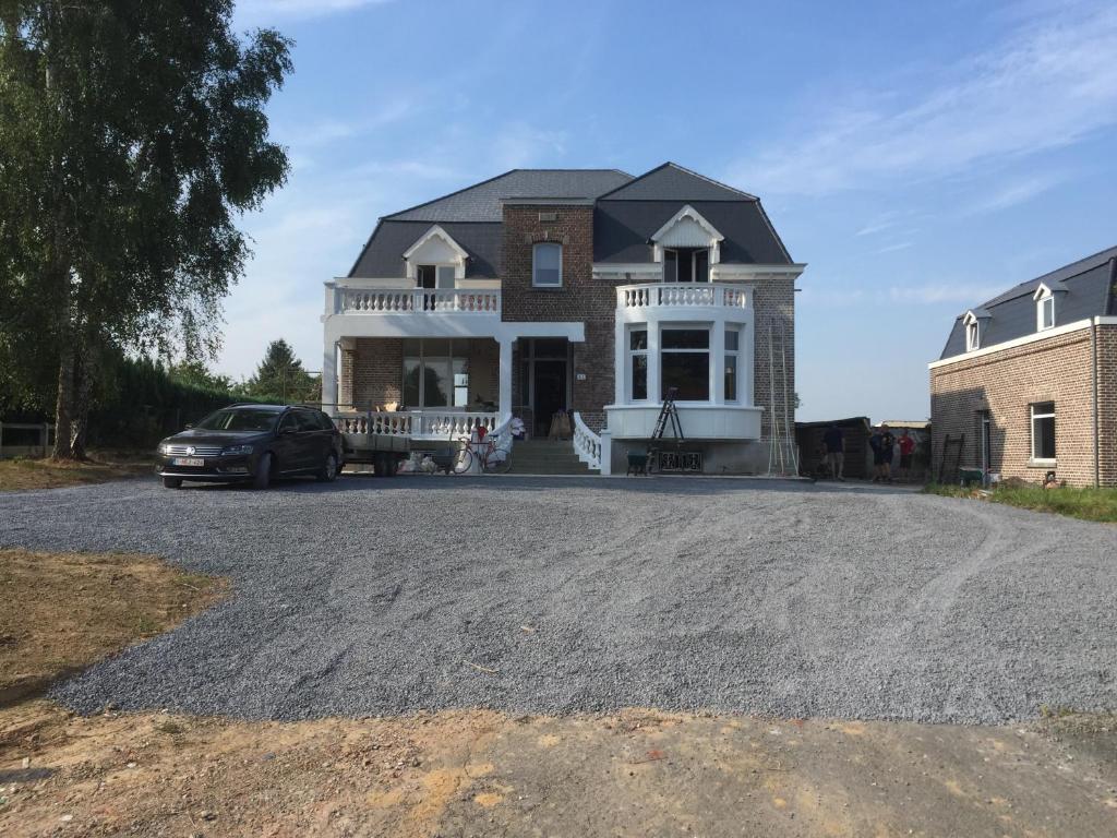 a large house with a car parked in the driveway at Gite la Blanche in Ogy