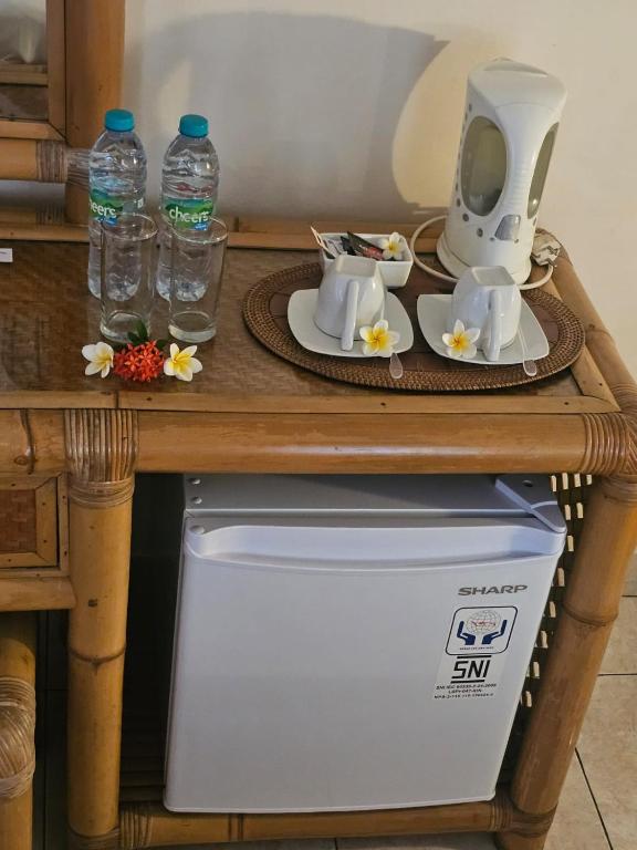 un tavolo con cesto e bottiglie d'acqua di Hotel Chonos a Lovina
