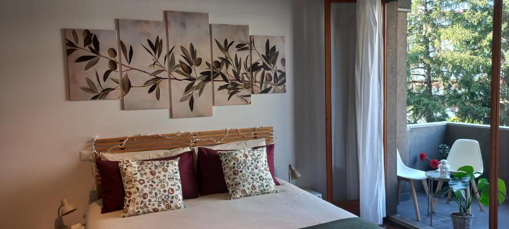 een slaapkamer met een bed met twee schilderijen aan de muur bij "LAGO VERDE" Como garage privato in Como