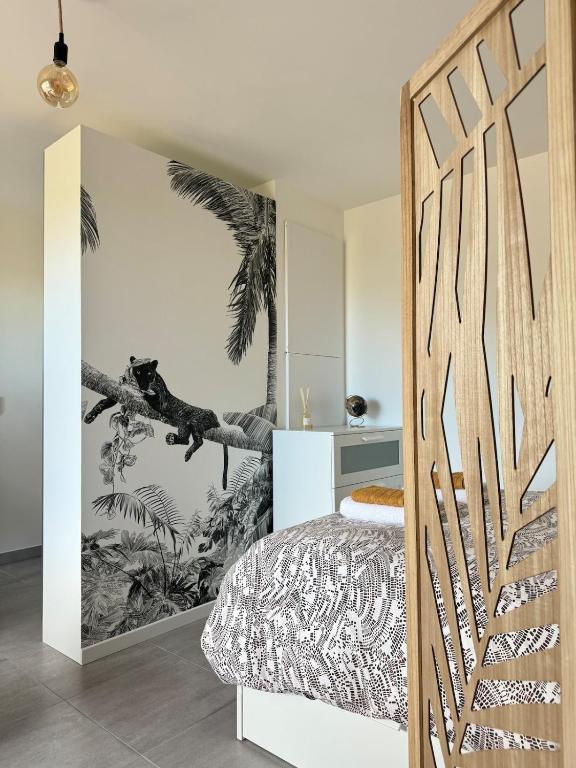 - une chambre avec un lit et une fresque murale de palmiers dans l'établissement Appartement cozy proche du centre Terrasse,Parking, à Montpellier