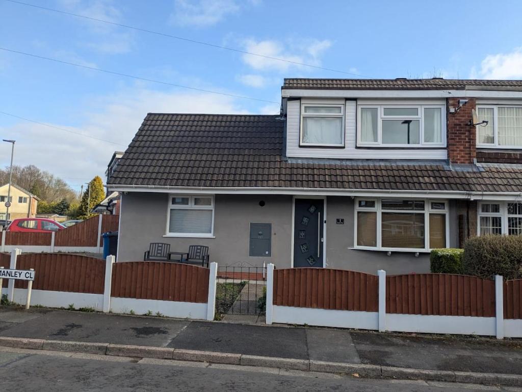 a house with a fence in front of it at Manley House - Close to Town Centre - Self-Check-In - Driveway Parking, Two Living Rooms, Garden Office, Smart TVs by Yoko Property in Leigh