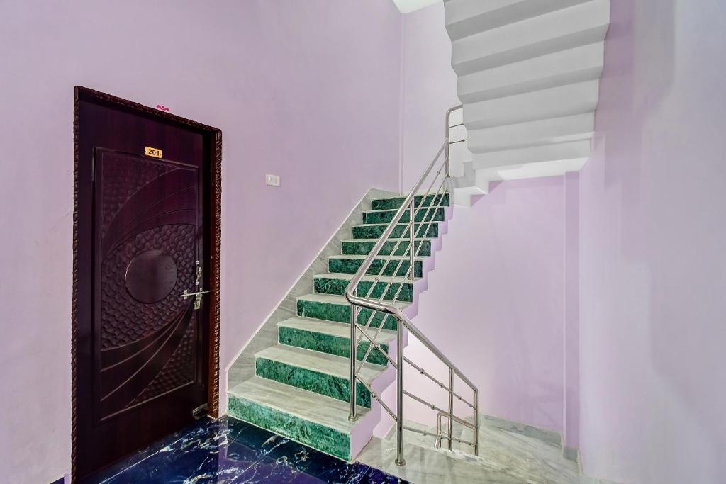 a staircase with green and white stairs and a door at Hotel O Heritage Inn in Cuttack