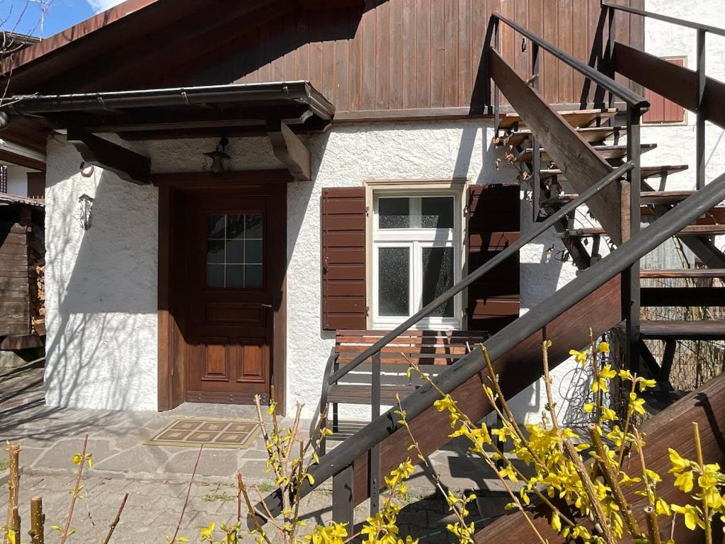 ein Haus mit einer Holztür und einer Treppe in der Unterkunft Ciasa Larese, between the lake and the Dolomites in Auronzo di Cadore