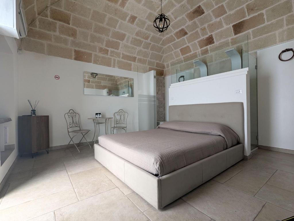 een slaapkamer met een bed, een tafel en stoelen bij Matilde Home in Monopoli