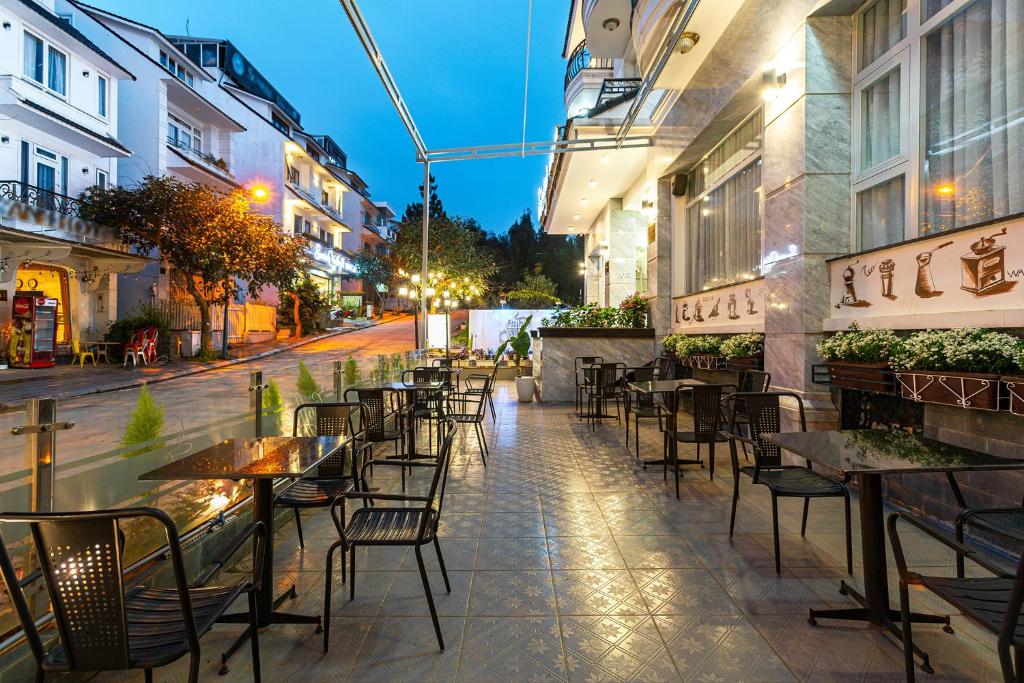 an empty sidewalk with tables and chairs on a street at Dalat Wind Hotel in Da Lat