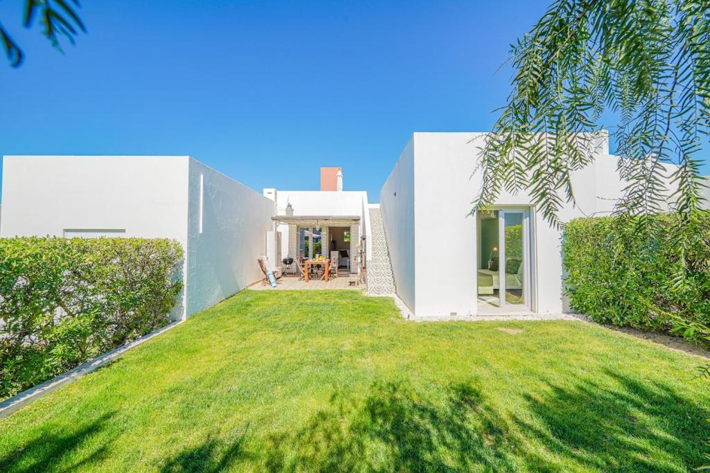 a white house with a large yard at HideAway by MOJE Holiday in Porches