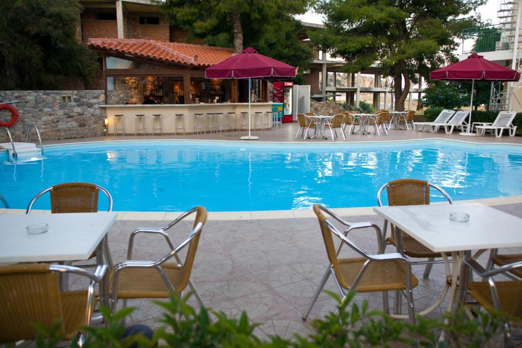 托隆的住宿－伊斯佩里亞酒店，大楼前的带桌椅的游泳池