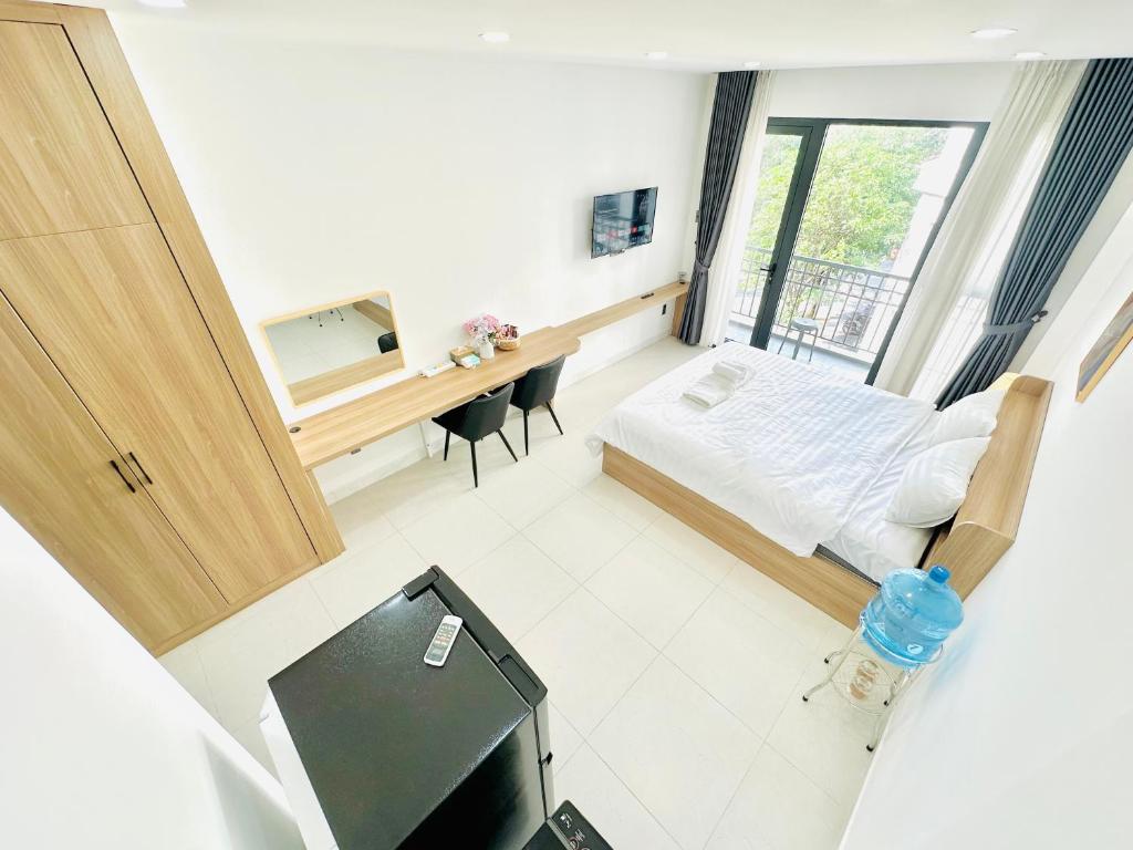 a bedroom with a bed and a desk with a television at 302 Modern Studio with Balcony & Kitchen in Ho Chi Minh City