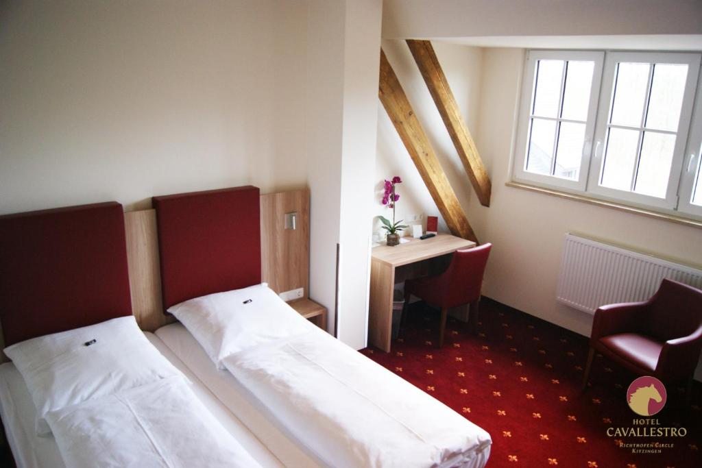 Schlafzimmer mit einem Bett, einem Schreibtisch und einem Fenster in der Unterkunft Cavallestro Classic in Kitzingen