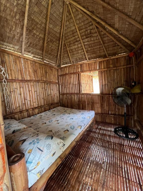 una camera con un letto in una capanna di paglia di Sharky Hostel Oslob a Oslob