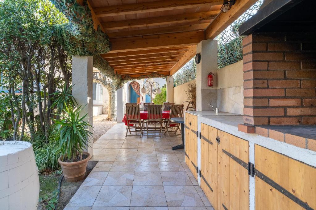 un patio extérieur avec une table et des chaises dans l'établissement MAISON DE CHARME PRES de la MER CLIMATISEE, à Saint-Cyr-sur-Mer