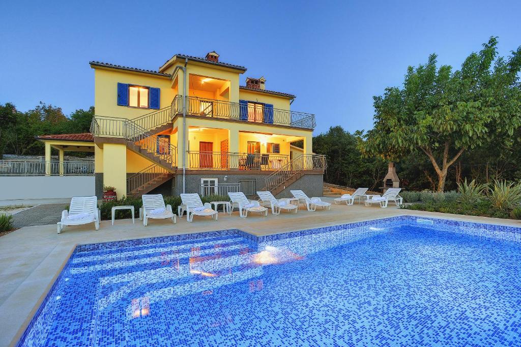 una casa con piscina delante de una casa en Villa Mytilus, a beautiful villa with a fantastic sea view, en Trgetari