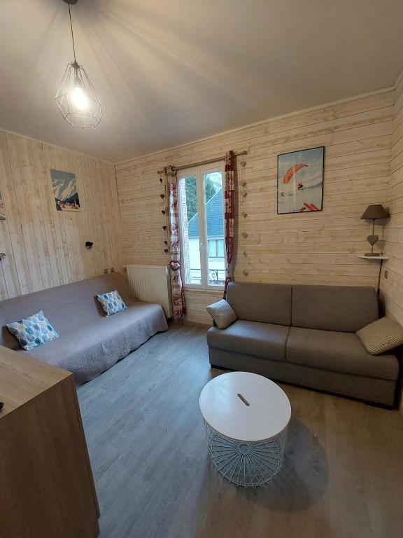 un salon avec un canapé et un lit dans l'établissement Charmant appartement - Le Mont Dore, à Le Mont-Dore