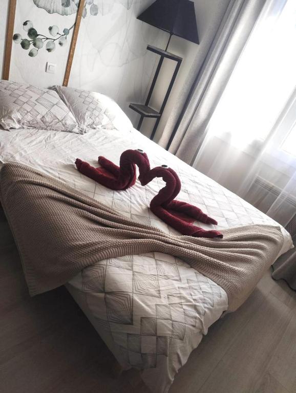 un ruban rouge posé au-dessus d'un lit dans l'établissement HSH FRANCE LOCATION Disney Land PARIS - Suite Nicolas - Appartement de charme, à Bussy-Saint-Georges