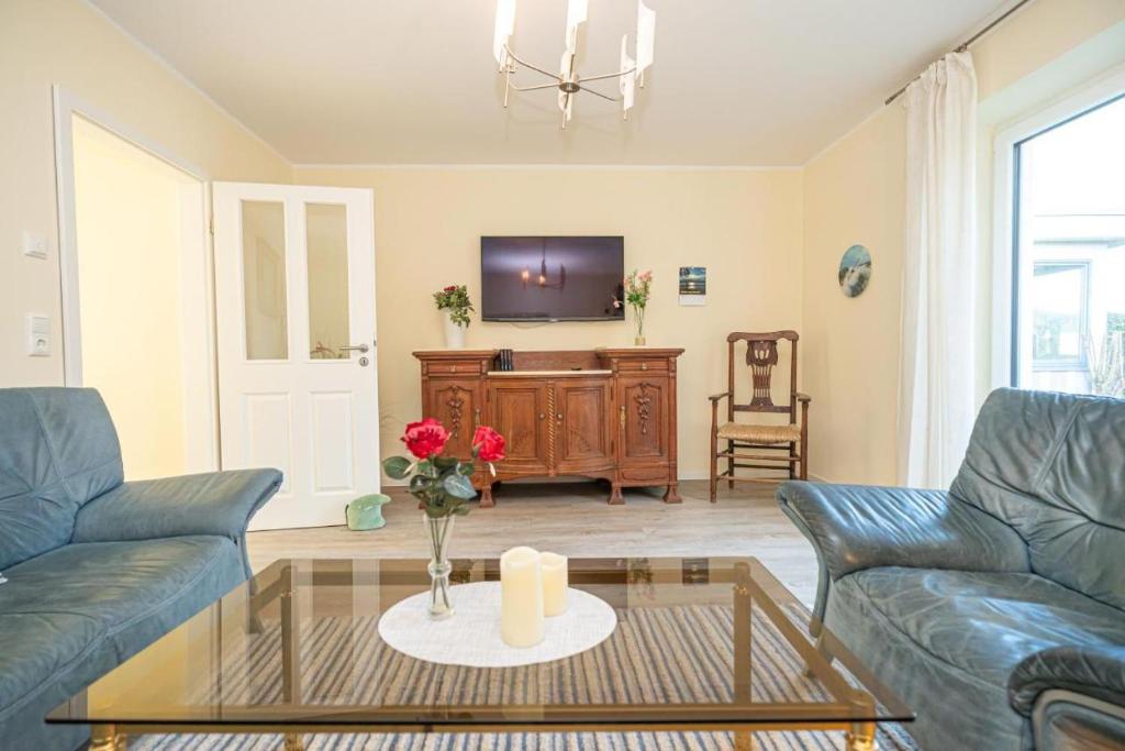 - un salon avec deux canapés bleus et une télévision dans l'établissement Hafenkoje Ferienhaus Vareler Hafen, à Varel