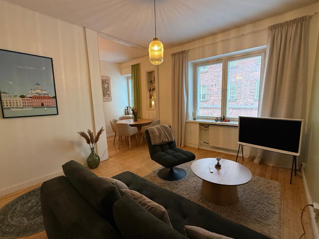 un salon avec un canapé et une télévision dans l'établissement Cozy studio in Punavuori, à Helsinki