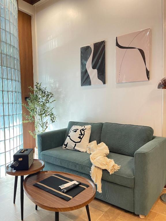 un soggiorno con un divano verde e un tavolo di Nueng Rana 113 Unique House in Chinatown 3BR 2BA a Samphanthawong